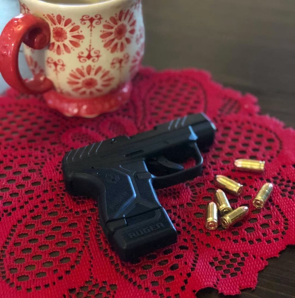 firearm and bullets on lace with coffee cup