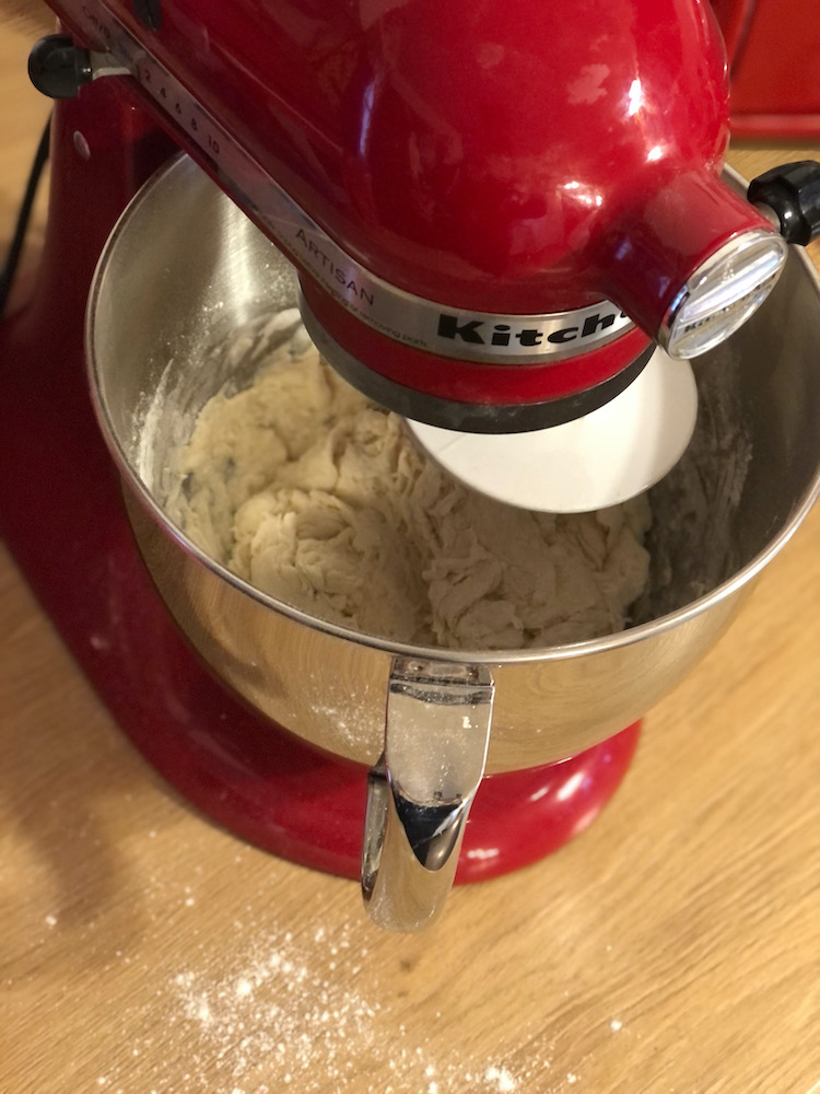 mixing crusty bread recipe in a red kitchen aid mixer