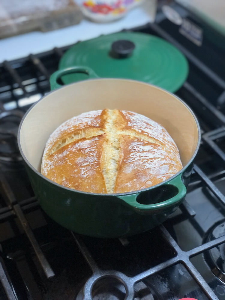 finished crusty bread fresh out of the oven in a dutch oven