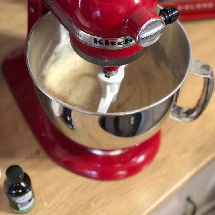 vanilla extract being mixed into recipe using a red kitchen aid mixer