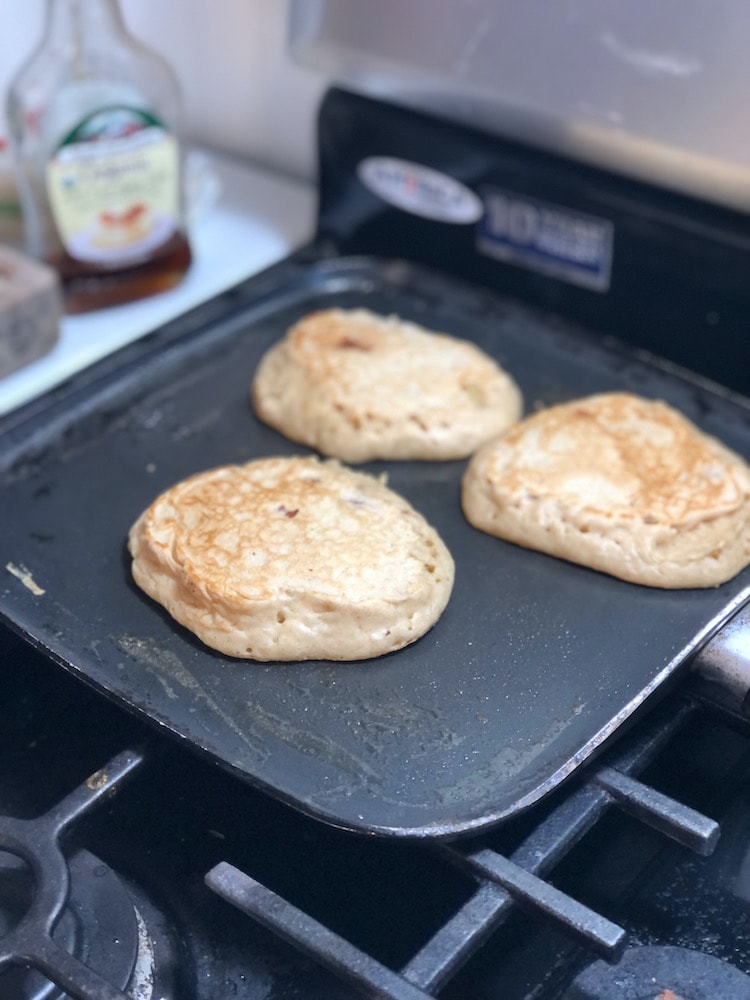 pancakes being cooked on a griddle