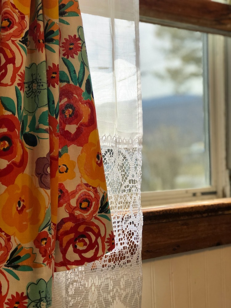 open window with colorful curtains and mountains in the background
